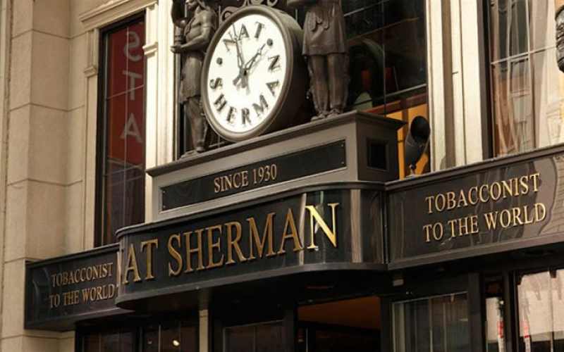 Exterior of the Nat Sherman tobacco store with a clock and Since 1930 sign above the entrance.