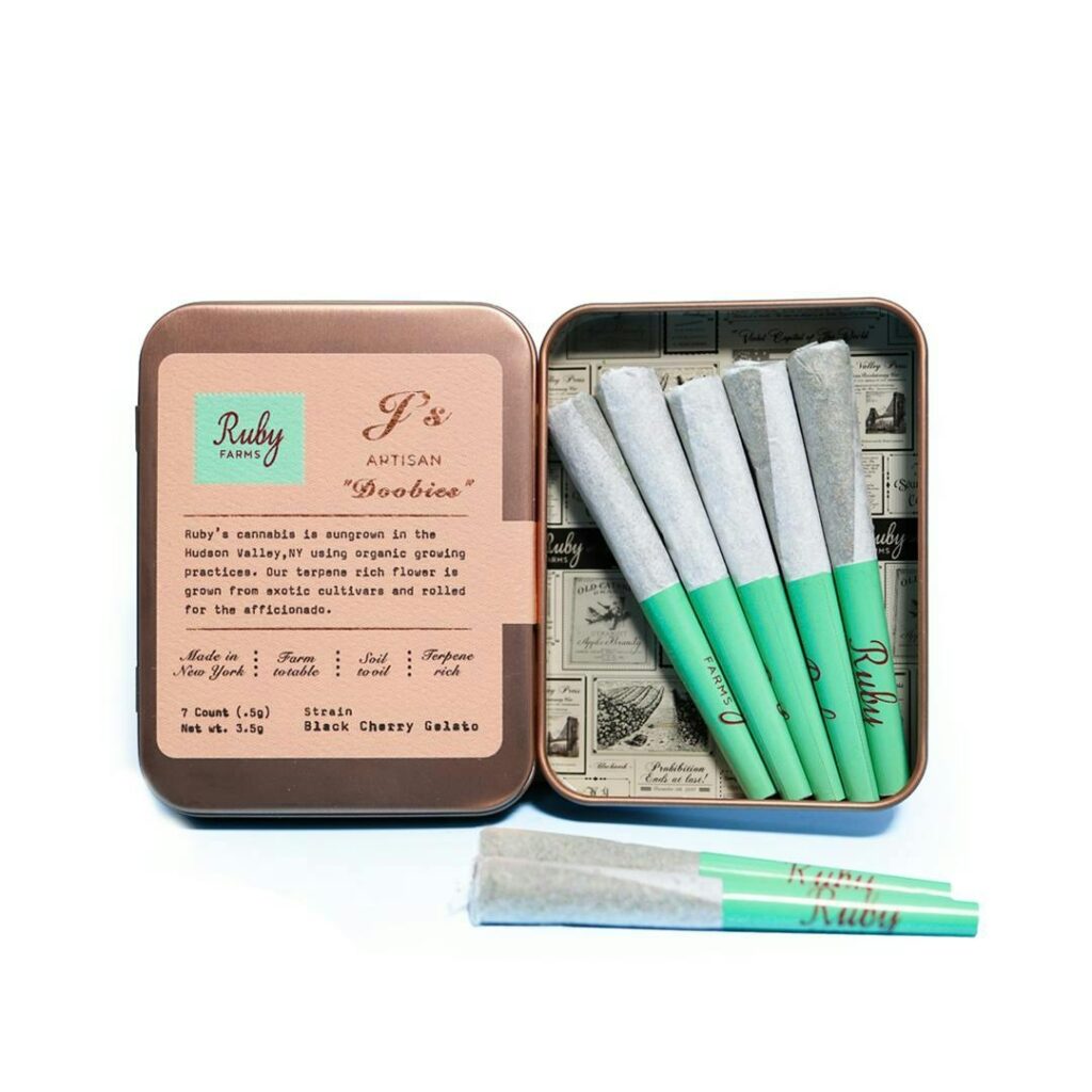 Open tin of pre-rolled joints labeled Ruby with green tips on a white background.