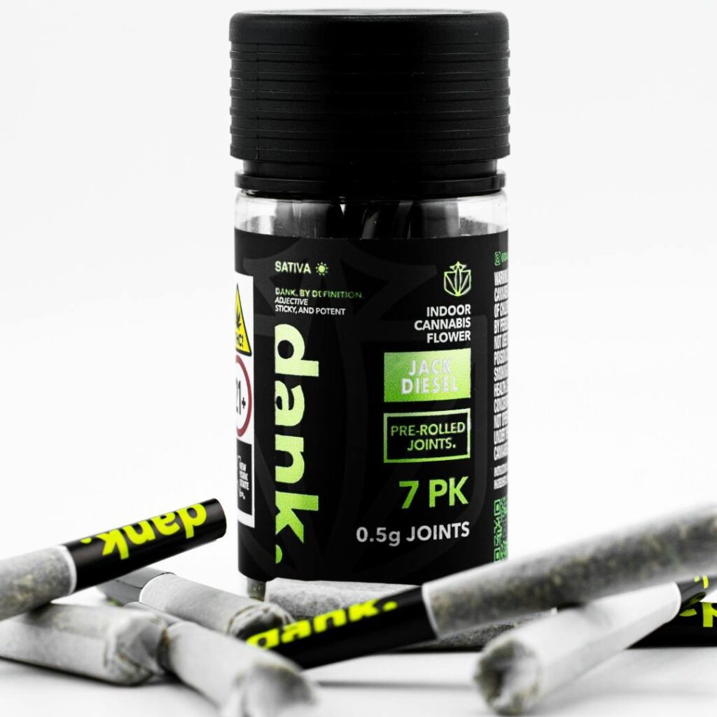 Container of pre-rolled cannabis joints labeled dank with scattered joints around it.