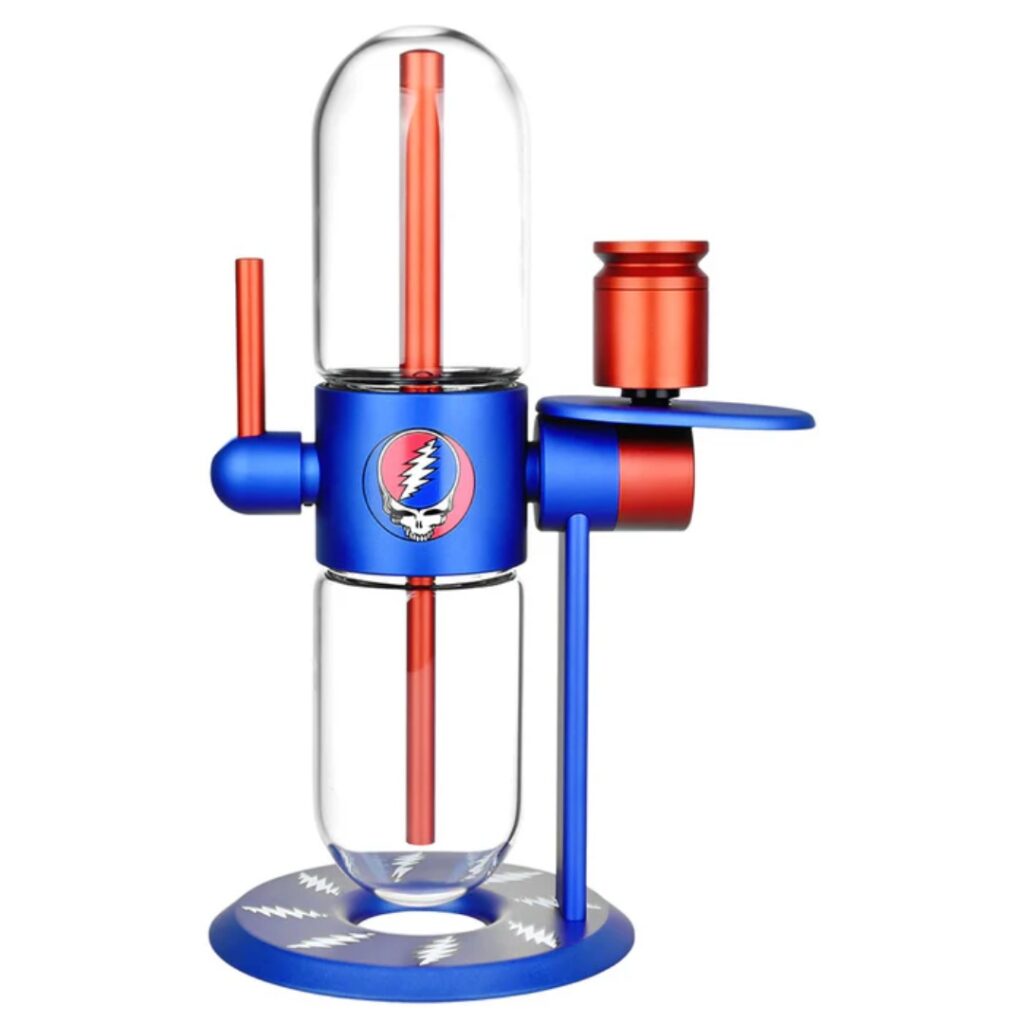 A blue and red glass bong with a Grateful Dead skull logo on the front, standing on a blue base.